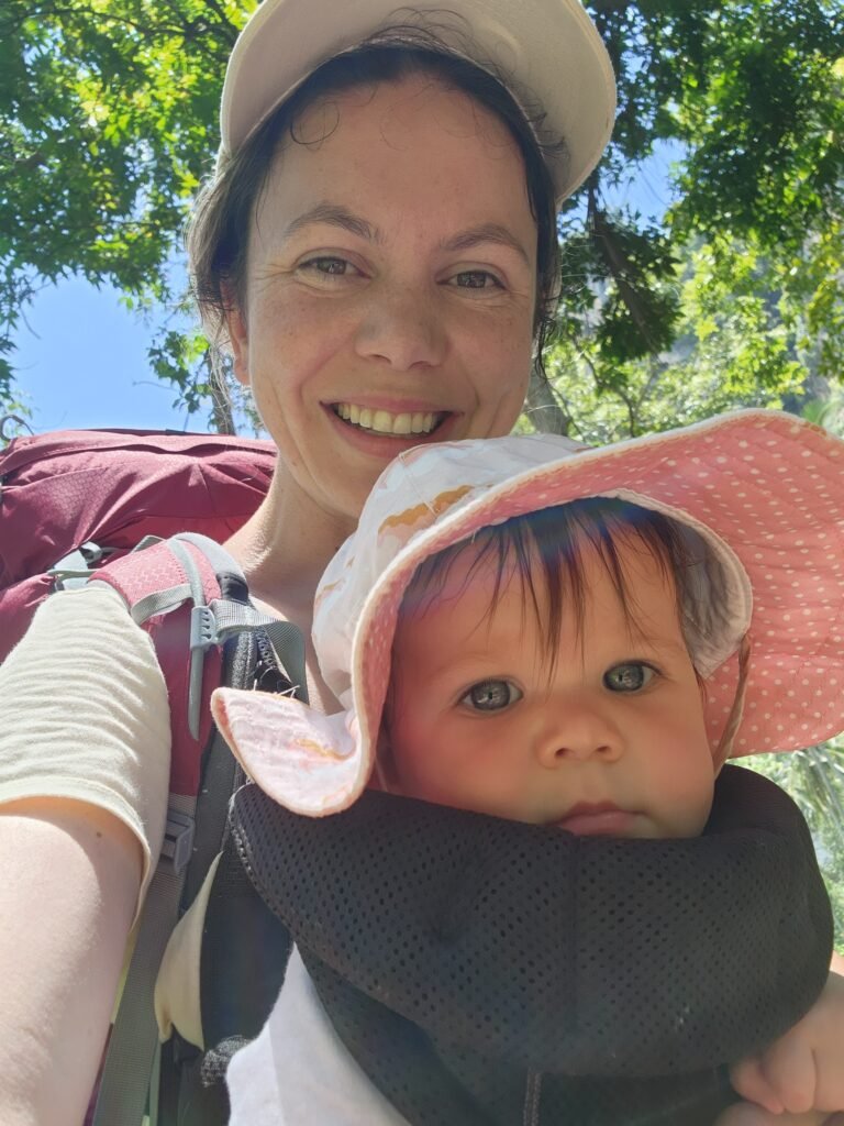 mum and her daughter in a baby carrier backpacking through the jungle in Thailand
