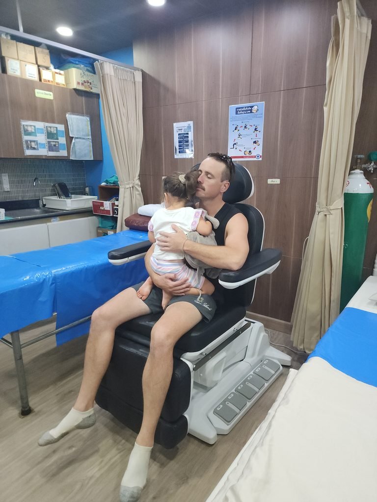 dad cuddling his daughter inside an emergency medical clinic in thailand