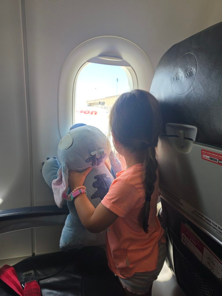 Young child looking out the plane window during a flight.