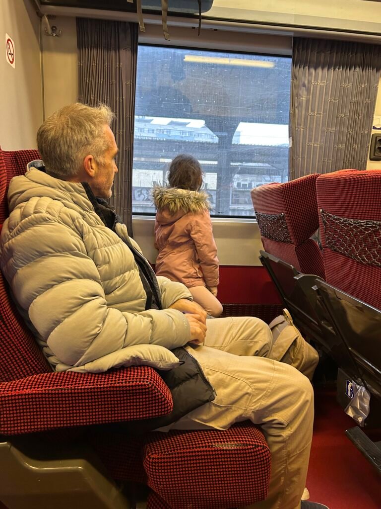 dad and her daughter on a train looking out the window traveling through turkiye