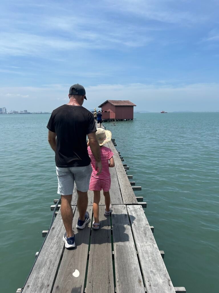 father and daughter walking along a pier while travelling